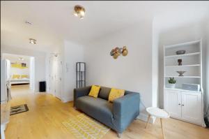 uma sala de estar com um sofá azul num quarto branco em New Spacious 1 bed studio flat in Aldgate em Londres