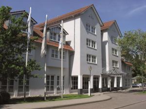 un edificio blanco con banderas delante en nestor Hotel Neckarsulm, en Neckarsulm