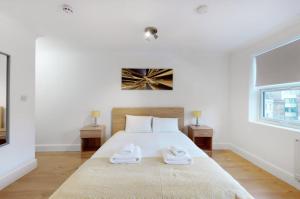 a bedroom with a bed with two towels on it at Modern split level 1 bedroom flat in Aldgate in London