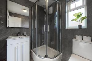 a bathroom with a shower and a toilet and a sink at Modern split level 1 bedroom flat in Aldgate in London