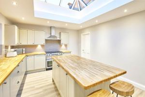 a kitchen with white cabinets and a skylight at Host & Stay- Graham House in Osmotherley