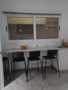 Andri' s place في Nea Paphos: طاولة مع كراسي ونوافذ في الغرفة