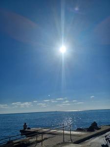 a man sitting on a bench looking at the ocean at Andri' s place in Nea Paphos +6 photos