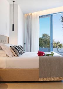 a bedroom with a large bed and a window at Oasis Beach Hotel in Skala