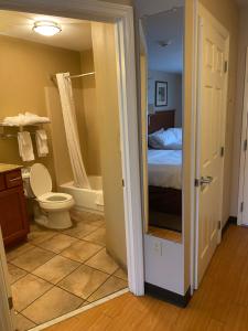 a bathroom with a bed and a toilet and a tub at Candlewood Williamsport, an IHG Hotel in Williamsport