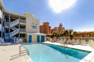 ein Pool mit Stühlen und ein Hotel in der Unterkunft Summer Breeze 21 in Orange Beach
