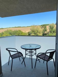 a table and two chairs on a balcony with a view at Apartmán Flower in Podhájska