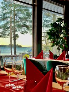 a table with wine glasses and a view of the ocean at Beach Hotel Santalahti in Kotka