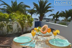 una mesa con un bol de fruta y vasos de zumo de naranja en Casa Maresía Las Moreras con Vista Mar en primera linea y Piscina compartida, en Playa Blanca