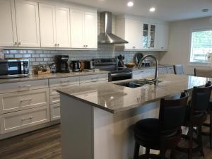 a kitchen with white cabinets and a kitchen island with a sink at Hammer Haus II in Waterloo