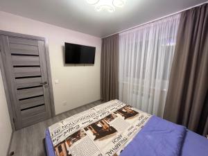 a bedroom with a bed with a newspaper on it at Стильна квартира в новому будинку, поряд центр та р. Дніпро in Cherkasy
