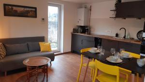 een woonkamer met een bank en een tafel met stoelen bij Lovely Green Lodge parking GRATUIT in Ribeauvillé