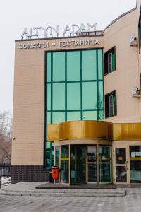 a building with a sign on the front of it at Altyn Adam Hotel in Petropavlovsk