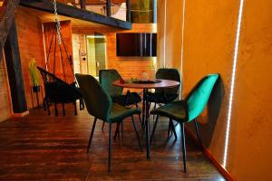 a dining room with a table and green chairs at Apartament Piorun in Mrągowo