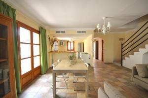 a living room with a table and chairs in it at Houm Villa Cala Pi in Cala Pi