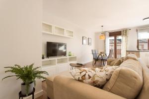 Una sala de estar con un sofá y un televisor. en Apartamento Zoraida Centro, en Granada
