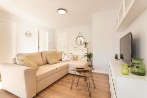 Una sala de estar blanca con un sofá y una mesa. en Apartamento Zoraida Centro, en Granada 9 fotos más