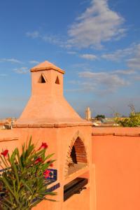 Un bâtiment orange avec une tour en haut dans l'établissement Riad Arbre Bleu, à Marrakech