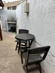 una mesa negra y un banco junto a una pared en Cabañas Costatour Quintero, en Quintero