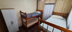 a small room with two bunk beds and a refrigerator at Hostel Caxias do Sul in Caxias do Sul