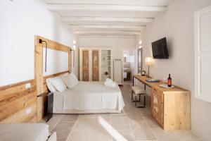 a bedroom with a bed and a desk and a television at Masseria Mongiò dell'Elefante in Otranto