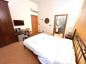 a bedroom with a bed and a desk and a television at Affittacamere Virginia's Rooms in Genoa