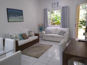 a living room with two couches and a table at Casa & Jardim Riviera in Riviera de São Lourenço