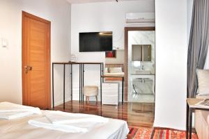 a hotel room with two beds and a table and a television at Million Old City Apartment in Istanbul