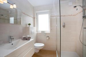 a bathroom with a toilet and a sink and a shower at Landhotel Fernsicht in Winterberg