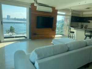 a living room with a couch and a large window at FRENTE PLAYA vista al mar, PISCINA DE USO EXCLUSIVO in Boca del Río
