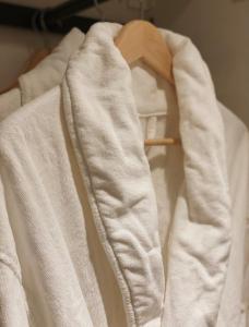 a white robe is hanging on a rack at LA Hotel in Lidingö