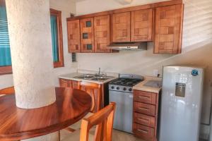 a small kitchen with a table and a refrigerator at Hotel Villas Punta Blanca in Zihuatanejo