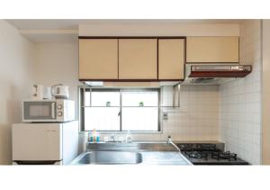 a kitchen with a sink and a microwave at Union Shin-Osaka 3F - Vacation STAY 12037 in Osaka