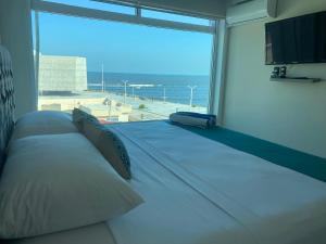 a large bed in a room with a large window at FRENTE PLAYA vista al mar, PISCINA DE USO EXCLUSIVO in Boca del Río