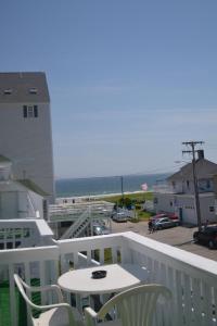 a balcony with a table and chairs and the ocean at The New Oceanic Inn in Old Orchard Beach