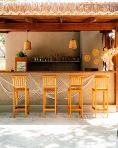 a table and four chairs in front of a bar at SITIO VILLA DA MATA in São Miguel dos Milagres