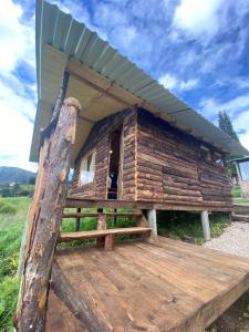 a log cabin with a roof on a wooden deck at Serás Libre Refugio in Zipaquirá