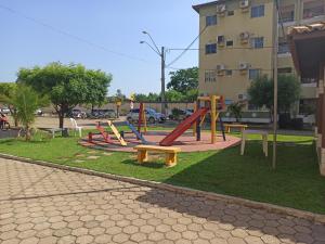 a park with slides and benches in front of a building at Apto dois quartos, cozinha equipada, portaria 24 h, área de lazer in Imperatriz