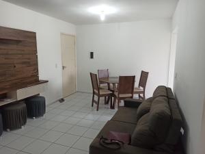 a living room with a couch and a table and chairs at Apto dois quartos, cozinha equipada, portaria 24 h, área de lazer in Imperatriz