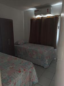 a small bedroom with two beds and a window at Apto dois quartos, cozinha equipada, portaria 24 h, área de lazer in Imperatriz