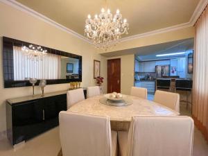 a dining room with a table with chairs and a chandelier at COP 30 - Luxurious and comfortable apartment right on Visconde de Souza Franco in Belém
