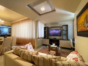 a living room with a couch and a television at COP 30 - Luxurious and comfortable apartment right on Visconde de Souza Franco in Belém