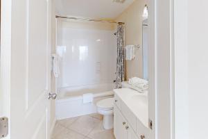 a white bathroom with a toilet and a shower at Dalarna in Orange Beach