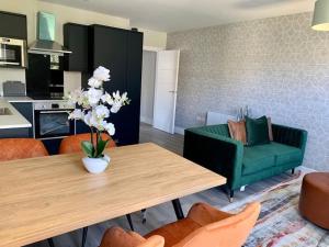 een woonkamer met een tafel en een groene bank bij Bright, Vibrant New 1 Bedroom Town Centre Parking in Bournemouth
