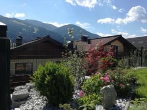 a garden in front of a house with mountains in the background at Appartement Fritzenwallner in Wagrain