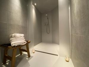 a bathroom with a shower and a pile of towels at CoCo Romantic - apartment in most trendy central hotspot of Antwerp in Antwerp