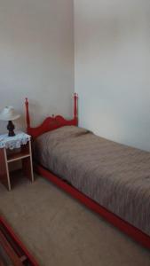 a bedroom with a bed and a table with a lamp at Alquiler Temporario Olavarría in Olavarría