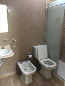 a bathroom with a toilet and a sink at Alquiler Temporario Olavarría in Olavarría