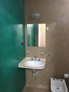 a bathroom with a sink and a mirror at Alquiler Temporario Olavarría in Olavarría