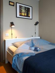 uma cama num quarto com duas lâmpadas e uma cama sidx sidx em SUNSET Apartment Near Sea - family friendly space with bath and good coffee em Ventspils